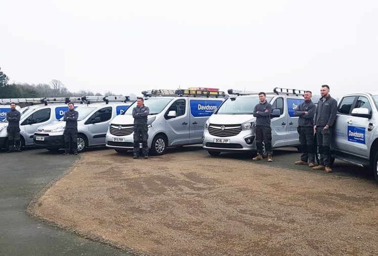 plumbing and heating engineers stood in front of Davidson's work vehicles