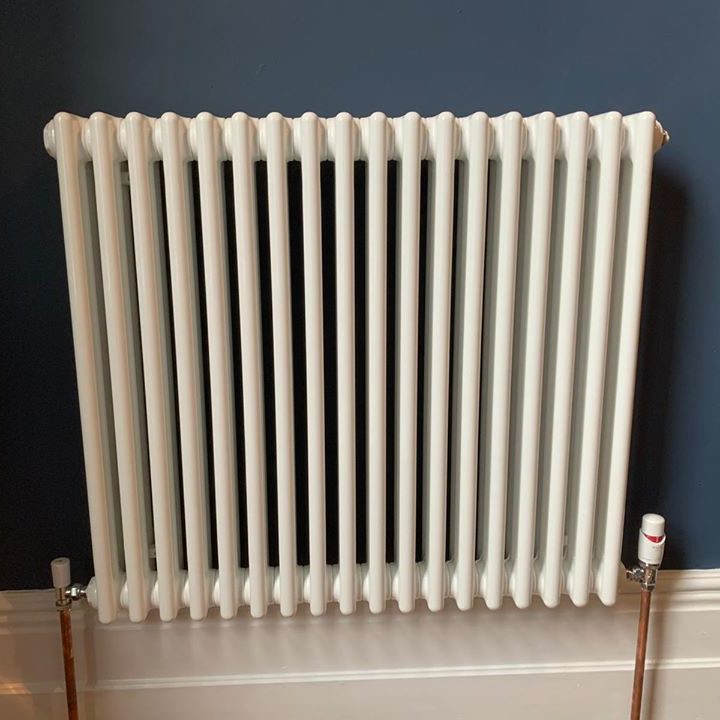 white designer radiator against blue wall