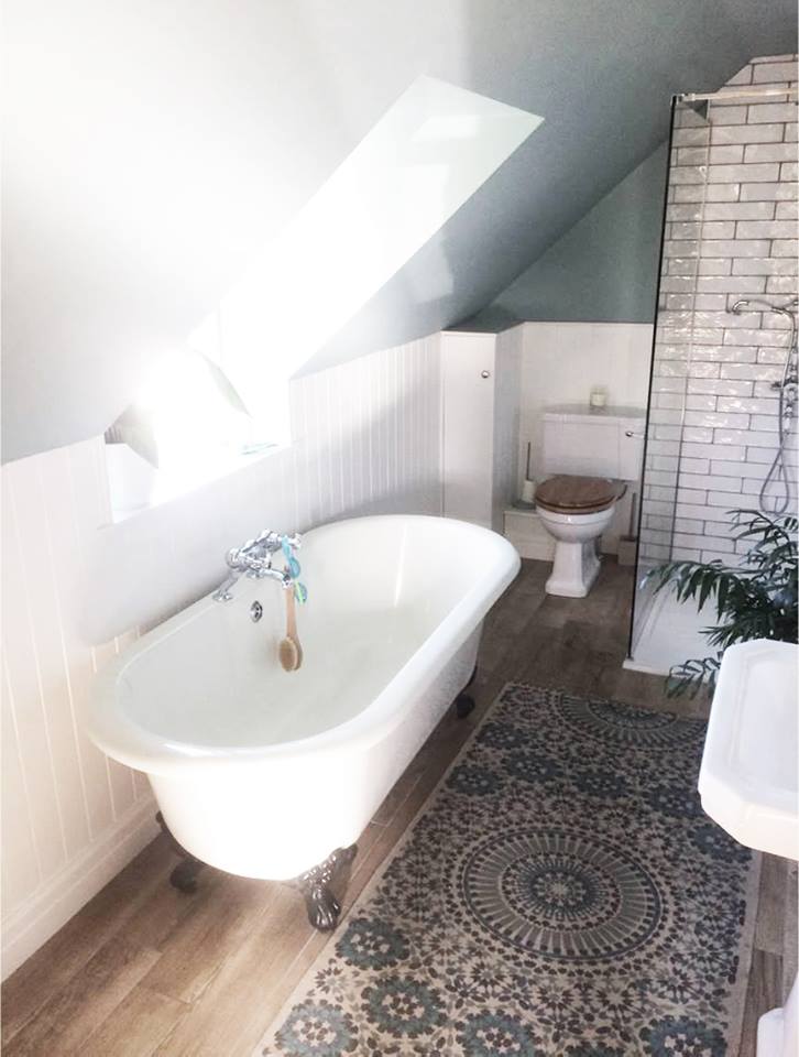free standing bath in newly renovated bathroom with light streaming through velux window
